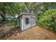 Exterior view of a shed with metal sliding door and a lot of overgrown foliage around the area at 129 5Th Jpv St, Winter Haven, FL 33880