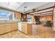 Spacious kitchen featuring an island with breakfast bar, wood cabinets, and tile floors at 1604 Nottingham Dr, Winter Park, FL 32792