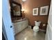 Stylish half-bath featuring marble countertops and unique framed mirror at 1056 Castle Pines Ct, Reunion, FL 34747