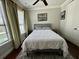 Cozy bedroom featuring neutral colors, a ceiling fan, and large windows at 1056 Castle Pines Ct, Reunion, FL 34747
