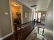 Bright hallway with wooden railing overlooking staircase and laundry room at 1056 Castle Pines Ct, Reunion, FL 34747