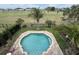 Stunning aerial view of a private pool surrounded by lush greenery and well-manicured landscaping at 1056 Castle Pines Ct, Reunion, FL 34747
