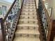 Elegant staircase showcases decorative tiled risers and dark wood banisters, adding a touch of sophistication to the home at 1056 Castle Pines Ct, Reunion, FL 34747