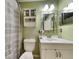 Green bathroom with a vanity, cabinet, mirror, toilet and shower with a grey curtain at 313 Morning Creek Cir, Apopka, FL 32712