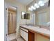 Bathroom featuring large mirrors, vanity, tile floors, and a shower-tub combo at 313 Morning Creek Cir, Apopka, FL 32712