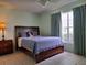 Bedroom features a blue bedspread, side table, and a large window with dark blue curtains at 313 Morning Creek Cir, Apopka, FL 32712