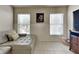 Comfortable living room with neutral tones, tile floors, and natural light from two windows at 313 Morning Creek Cir, Apopka, FL 32712