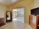 Main bedroom featuring tile floors, vaulted ceilings, and sliding door access to patio at 313 Morning Creek Cir, Apopka, FL 32712