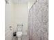 Cozy bathroom with neutral color, a standard toilet, and a tub-shower combo with a decorative shower curtain at 5616 Siltstone St, Lakeland, FL 33811