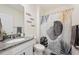 Bathroom featuring granite countertop, tile flooring and vanity with modern faucet fixtures and a decorative shower curtain at 5616 Siltstone St, Lakeland, FL 33811