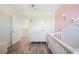 A baby's Bedroom with a pink accent wall, a white baby crib and wood flooring at 5616 Siltstone St, Lakeland, FL 33811