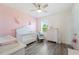 Charming Bedroom with a white crib, floral decorations, and a glider chair, perfect for a baby's room at 5616 Siltstone St, Lakeland, FL 33811