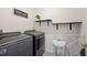 Functional laundry room equipped with modern washer and dryer units, complemented by minimalist decor at 5616 Siltstone St, Lakeland, FL 33811