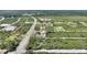 Aerial view of new home featuring a neutral exterior, driveway, and surrounding undeveloped land in a rural community at 2021 Valencia Dr, Indian Lake Estates, FL 33855