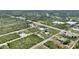 An aerial view captures the layout of the entire area, featuring houses, roads, and lush trees at 2021 Valencia Dr, Indian Lake Estates, FL 33855