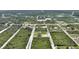 Aerial view of new home featuring a neutral exterior, driveway, and surrounding undeveloped land in a rural community at 2021 Valencia Dr, Indian Lake Estates, FL 33855
