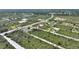 Aerial view of new home featuring a neutral exterior, driveway, and surrounding undeveloped land in a rural community at 2021 Valencia Dr, Indian Lake Estates, FL 33855