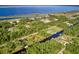 An aerial view of homes along canals leading to a large lake, surrounded by lush green trees at 2021 Valencia Dr, Indian Lake Estates, FL 33855