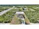 Aerial view of new home featuring a neutral exterior, driveway, and surrounding undeveloped land at 2021 Valencia Dr, Indian Lake Estates, FL 33855