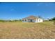 Back exterior view of a home with a spacious lawn at 2021 Valencia Dr, Indian Lake Estates, FL 33855