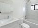 Bright bathroom features a tub-shower combo with white tile surround and a vanity with countertop sink at 2021 Valencia Dr, Indian Lake Estates, FL 33855
