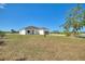 Exterior view of a charming single-story home with a driveway and landscaping at 2021 Valencia Dr, Indian Lake Estates, FL 33855