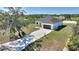 Aerial view of single-story home with long driveway and lush green landscaping at 2021 Valencia Dr, Indian Lake Estates, FL 33855