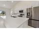 Modern kitchen with stainless steel appliances, white cabinetry, and quartz countertops at 2021 Valencia Dr, Indian Lake Estates, FL 33855