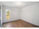 Bright bedroom featuring wood-look floors, a window, and neutral wall paint at 3055 Steeplechase Dr, Lakeland, FL 33811