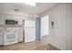 Practical kitchen featuring white cabinets, appliances, and linoleum floors, adjacent to another room at 3055 Steeplechase Dr, Lakeland, FL 33811