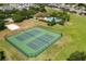 Community aerial view featuring tennis courts, a sand volleyball court, and a luxurious swimming pool at 547 Windsor Pl, Davenport, FL 33896
