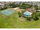 Aerial showcasing the community pool, tennis court, and volleyball court amidst lush landscaping at 547 Windsor Pl, Davenport, FL 33896