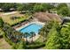 Aerial view showcases community pool and lounge area, nestled among lush greenery at 547 Windsor Pl, Davenport, FL 33896