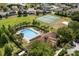 Aerial view of community pool, tennis courts, and surrounding residences at 547 Windsor Pl, Davenport, FL 33896