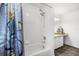 Bright bathroom featuring a shower-tub combo, complete with tile surround and modern fixtures at 547 Windsor Pl, Davenport, FL 33896