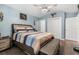 Light-filled bedroom featuring hardwood floors, complemented by a ceiling fan and a calming blue wall color at 547 Windsor Pl, Davenport, FL 33896