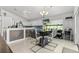Open dining area featuring a modern table set, bright lighting, and seamless access to the kitchen at 547 Windsor Pl, Davenport, FL 33896