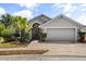 Charming single-Gathering home with a well-manicured lawn, mature landscaping, and a two-car garage on a sunny day at 547 Windsor Pl, Davenport, FL 33896