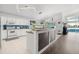 Well-lit kitchen boasts white cabinetry, stainless appliances, and breakfast bar with modern pendant lighting at 547 Windsor Pl, Davenport, FL 33896