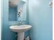 A quaint powder room with a pedestal sink and simple decor at 547 Windsor Pl, Davenport, FL 33896