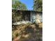 Exterior shot of enclosed porch with trees, grass, and a door at 4266 County Road 691, Webster, FL 33597