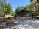 Cozy single-story home with a metal carport, surrounded by lush trees and a large yard at 4266 County Road 691, Webster, FL 33597