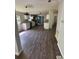Open concept kitchen with stainless steel appliances, white cabinets, and wood-style flooring at 4266 County Road 691, Webster, FL 33597