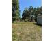 Exterior view of a cozy home with a spacious side yard and mature trees at 4266 County Road 691, Webster, FL 33597