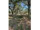 View of a grassy fenced in yard with mature trees at 4266 County Road 691, Webster, FL 33597