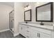 Bathroom featuring double sink vanity with granite countertop, framed mirrors, and glass enclosed shower at 7688 Somersworth Dr, Kissimmee, FL 34747