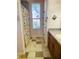 Charming bathroom featuring stone floors, floral window accents, and decorative shower curtain at 208 Shepard Ave, Dundee, FL 33838