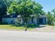 Charming single-story home featuring a well-manicured lawn and a large tree providing shade, perfect curb appeal at 208 Shepard Ave, Dundee, FL 33838