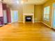 Open floor plan featuring hardwood floors, a fireplace, and large windows at 208 Shepard Ave, Dundee, FL 33838