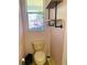 Quaint powder room with custom shelving and decorated glass window at 208 Shepard Ave, Dundee, FL 33838